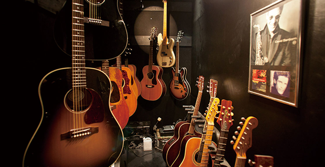 店内に置かれた沢山のギターと壁にかけられたアーティストの写真